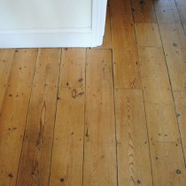 A wooden floor with DraughtEx fitted between the gaps