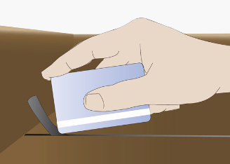 A hand using an old credit to insert the final 1-2 inches of DraughtEx floor gap fixer