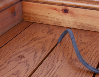 DraughtEx being stretched into a narrow gap between two floorboards
