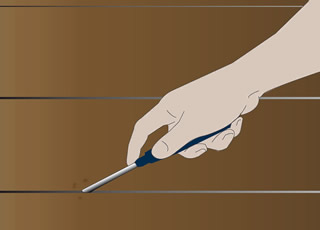 Cleaning the floorboard gaps using a screwdriver